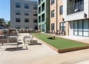 Thumbnail 25 of 28 - Hibernia resident amenity deck with gaming turf, conversational seating and grilling station at Hibernia Apartments, Missouri, 63139