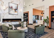 Thumbnail 15 of 28 - A living room with a fireplace, a painting on the wall, and a green armchair at Montage at Hawk Ridge Apartments, Missouri, 63367