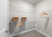 Thumbnail 10 of 28 - A white closet with a grey carpet and two baskets on the shelf at Hawk Ridge Apartments, Lake St. Louis, 63367