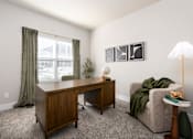 Thumbnail 5 of 28 - A room with a desk, chair, and lamp at Hawk Ridge Apartments, Lake St. Louis, Missouri