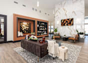 Thumbnail 14 of 28 - A modern living room with a wooden coffee table and a large painting on the wall at Montage at Hawk Ridge Apartments, Lake St. Louis, 63367, Missouri