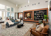 Thumbnail 12 of 28 - A living room with a blue couch and a brown chair at Montage at Hawk Ridge Apartments, Lake St. Louis