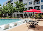 Thumbnail 42 of 47 - our apartments have a large pool and patio with chairs and umbrellas at Grand Flats, St. Louis, MO, 63104