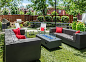 Thumbnail 39 of 47 - a backyard patio with couches and chairs and a fire pit at Grand Flats, St. Louis, MO