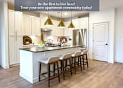 Thumbnail 28 of 28 - A kitchen with white cabinets and a central island with bar stools.