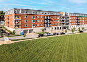 Thumbnail 33 of 33 - A large building with a green lawn in front.