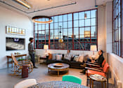 Thumbnail 3 of 39 - Steelcote Lofts clubroom with conversational seating, TV and oversized windows  at Steelcote Square, St. Louis, MO
