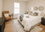 Thumbnail 7 of 19 - a bedroom with a bed and a chair and a window at 44 West Luxury Living, Valley Park, Missouri
