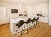 Thumbnail 16 of 19 - a large white kitchen with a white island and black chairs at 44 West Luxury Living, Valley Park