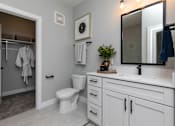 Thumbnail 15 of 36 - A bathroom with a toilet, sink, and mirror at The Cunningham Apartments, Iowa, 50266