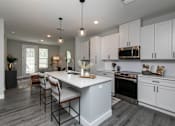 Thumbnail 1 of 36 - A modern kitchen with a large island and stainless steel appliances. at The Cunningham Apartments, West Des Moines, Iowa