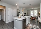 Thumbnail 6 of 36 - A modern kitchen with a large island and a dining area. at The Cunningham Apartments, West Des Moines, IA, 50266