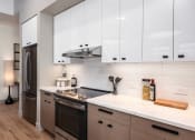Thumbnail 12 of 58 - a kitchen with white cabinets and a stove and a refrigerator at Bemiston Place Apartments, Clayton Missouri