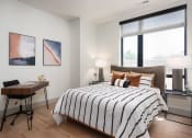 Thumbnail 15 of 58 - a bedroom with a bed and a large window at Bemiston Place Apartments, Missouri