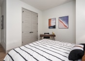 Thumbnail 16 of 58 - a bedroom with a bed and two paintings on the wall at Bemiston Place Apartments, Clayton Missouri