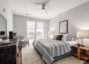 Thumbnail 51 of 71 - a bedroom with a large bed and a large window at The Flats & Terraces at Wildhorse Village, Chesterfield, Missouri