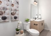 Thumbnail 50 of 71 - a bathroom with a toilet and a sink and a mirror at The Flats & Terraces at Wildhorse Village, Chesterfield, MO