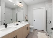 Thumbnail 53 of 71 - a bathroom with two sinks and a shower and a toilet at The Flats & Terraces at Wildhorse Village, Chesterfield