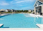 Thumbnail 27 of 34 - A large swimming pool with a building on the right side.