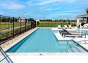 Thumbnail 28 of 34 - A black fence surrounds a small pool with a few chairs around it.