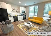 Thumbnail 18 of 21 - a living room with a yellow couch and a kitchen in the background  at Expo at Forest Park, St. Louis, MO, 63112