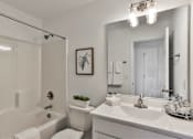 Thumbnail 13 of 33 - A white bathroom with a towel on the toilet.