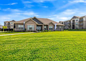 Thumbnail 25 of 33 - A row of houses with a green lawn in front.