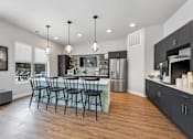 Thumbnail 27 of 33 - A modern kitchen with a dining table and chairs.