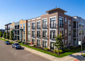 Thumbnail 10 of 26 - Modern apartment building with brick and contemporary facade at GrandView Flats and Townhomes Apartments, Granger, 46530