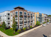 Thumbnail 9 of 26 - Modern townhome building with balconies and street view at GrandView Flats and Townhomes Apartments, Granger, Indiana