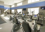 Thumbnail 8 of 23 - A gym with treadmills and elliptical machines.