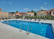 Thumbnail 37 of 45 - a swimming pool with lounge chairs around it and apartments in the background at The Residences at Toscana Park, Granger