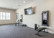 Thumbnail 60 of 66 - A spacious room with a bench, television, and exercise equipment.at Preserve at Sycamore Creek, Missouri 65065
