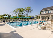 Thumbnail 39 of 66 - A pool with blue loungers and a building in the background.at Preserve at Sycamore Creek, Osage Beach, MO