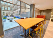 Thumbnail 12 of 17 - clubroom/resident lounge large work table overlooking courtyard  at The Residences at Delmar DivINe, St Louis, MO, 63112