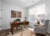 Thumbnail 18 of 71 - 3rd bedroom/home office with rick plank flooring, oversized windows with custom shades, desk and arm chair at The Flats & Terraces at Wildhorse Village, Chesterfield, 63005