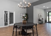 Thumbnail 11 of 18 - A dining room with a round table and chairs.