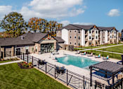 Thumbnail 1 of 18 - A large building with a pool in front of it.