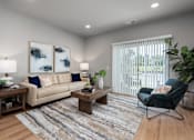 Thumbnail 9 of 18 - A living room with a beige couch, a wooden coffee table, and a rug.