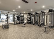Thumbnail 13 of 22 - A gym with a variety of equipment including weights and a bench.