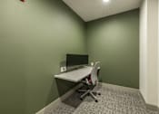 Thumbnail 21 of 22 - A white desk with a computer and chair in a room with green walls.