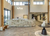 Thumbnail 5 of 22 - A reception area with a stone counter and a black table.
