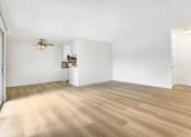 Thumbnail 2 of 12 - A room with a ceiling fan and wooden flooring.