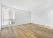 Thumbnail 7 of 12 - A room with wooden flooring and a window with blinds.