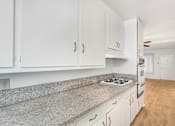 Thumbnail 4 of 9 - A kitchen with white cabinets and a granite countertop.