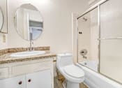 Thumbnail 7 of 9 - A white toilet sits next to a sink in a bathroom.
