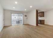 Thumbnail 1 of 11 - A spacious room with wooden flooring and a sliding door leading to a balcony.