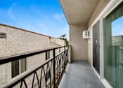 Thumbnail 2 of 11 - A balcony with a black railing and a glass door.