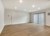 Thumbnail 3 of 11 - A room with wooden flooring and white walls.