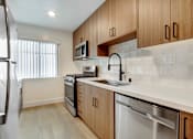 Thumbnail 4 of 11 - A kitchen with wooden cabinets and stainless steel appliances.